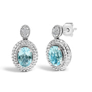 Bids.com .925 Sterling Silver Diamond Accent and  Oval Blue Topaz with Beaded Halo Drop Stud Earrings (I-J color, I1-I2 Clarity) Earrings