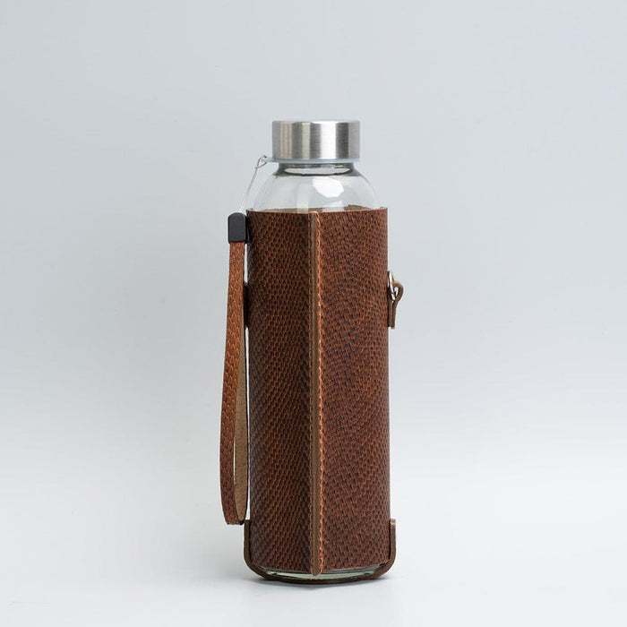 Leather water bottle holder with strap and glass bottle by Geometric Goods